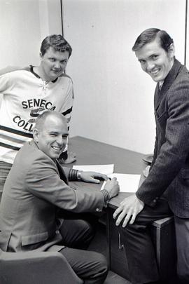 Mr. Summerville And A Football Player Signing A Contract